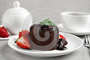 Delicious warm chocolate lava cake with mint and strawberries photo
