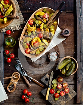 Delicious warm vegetable salad with baked potatoes, fried mushrooms, cherry tomatoes, pickles
