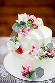 Delicious wedding cake decorated white icing with exotic flowers