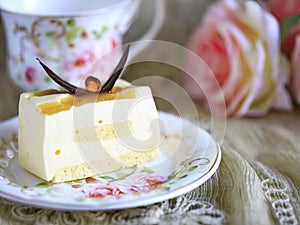 Delicious white chocolate cake and a beautiful cup of tea for wonderful morning in soft blurred background