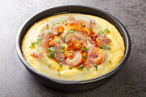 Delicious yellow grits with cheese, shrimps and bacon close-up in a plate. horizontal