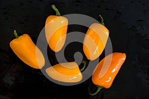 Delicious Yellow and Orange Peppers on Black Background