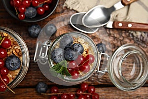 Delicious yogurt parfait with fresh berries and mint on wooden table, flat lay