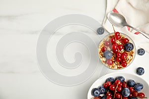 Delicious yogurt parfait with fresh berries on white table, flat lay. Space for text