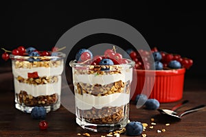 Delicious yogurt parfait with fresh berries on wooden table