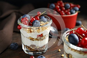 Delicious yogurt parfait with fresh berries on wooden table, closeup