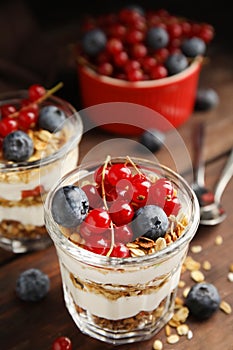 Delicious yogurt parfait with fresh berries on wooden table, closeup