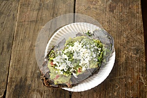 Mexican tlacoyos, a dish made with blue corn and filled with fried beans or broad beans, similar to mexican gordita, with guacamol