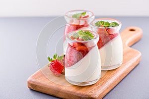 Delicous and nutritious double color colour strawberry desserts with mint and diced sarcocarp topping  with airy blue