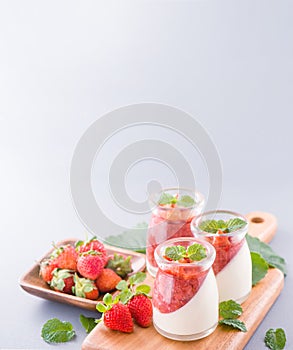 Delicous and nutritious double color colour strawberry desserts with mint and diced sarcocarp topping  with airy blue