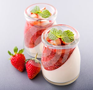 Delicous and nutritious double color colour strawberry desserts with mint and diced sarcocarp topping isolated with airy blue