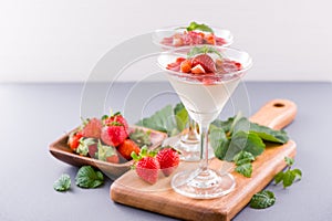 Delicous and nutritious double color colour strawberry desserts with mint and diced sarcocarp topping isolated with airy blue