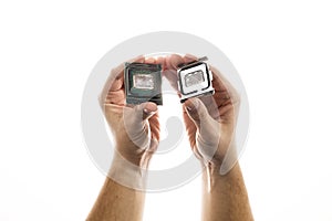 Delidded CPU with old thermal paste and glue in man`s hand isolated on white background.