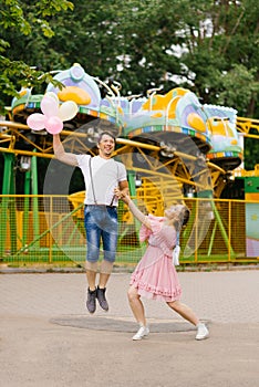 Delighted adult couple is having fun together in an outdoor amusement park during their leisure time. The concept of the lifestyle