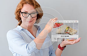 Delighted adult woman holding tablet