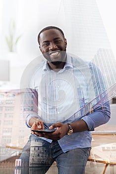 Delighted African American holding telephone