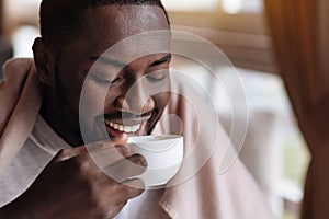 Delighted African American man enjoying the cup of tea