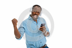 Delighted afro American man enjoying his favourite music