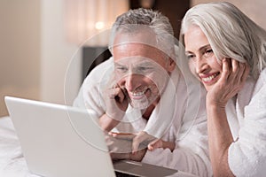 Delighted aged couple watching a movie at home