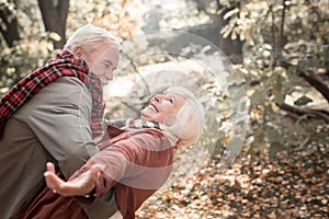 Delighted aged woman being held by her husband