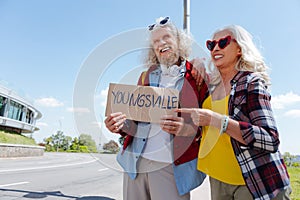 Delighted aged woman pointing at the sign