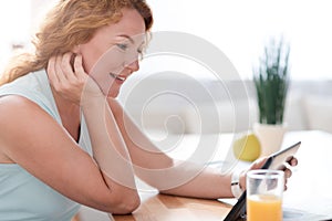 Delighted beautiful woman using tablet