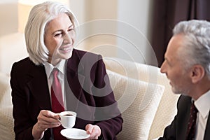 Delighted businesswoman having the conversation with her colleague