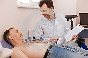 Delighted cardiologist telling the patient about his progress