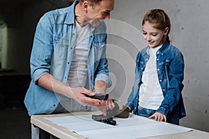 Delighted cheerful father pointing at the disassembled gun