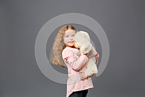 Delighted cute girl standing with her toy