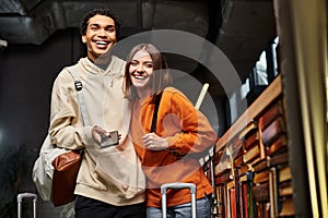 Delighted and diverse couple with smartphone