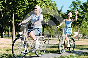 Delighted elderly woman riding a bike