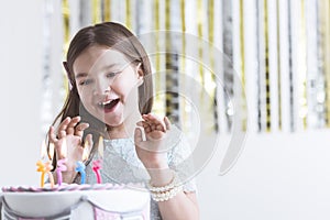 Delighted girl and birthday cake