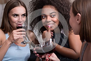 Delighted girls drinking wine and communicating