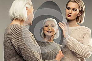 Delighted good looking aged woman smiling to herself