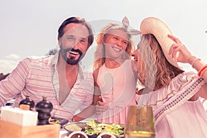 Delighted happy family sitting together at the table