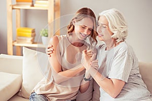 Delighted happy woman and her grandmother embracing