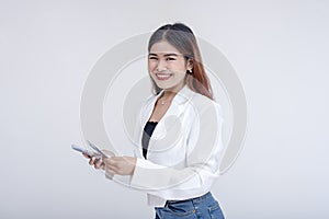 A delighted and joyful young woman looking at the camera while counting money. Isolated on a white background