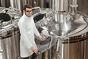 Delighted man using computer at beer factory