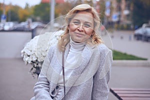 Delighted mature woman posing on the street