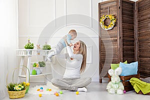 Delighted mother and her child enjoying the Easter egg hunt at home