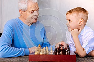 Delighted nice boy playing chess