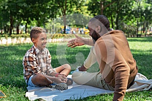 Delighted nice man telling a story to his son