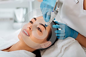 Delighted nice woman enjoying the hydrafacial procedure