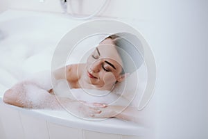 Delighted nice woman enjoying warm bath after working days