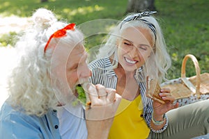 Delighted nice woman holding a sandwich