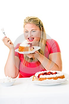 Delighted overweight woman with cream cakes