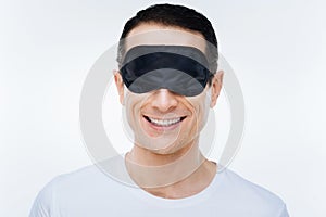 Delighted positive man wearing a sleeping mask