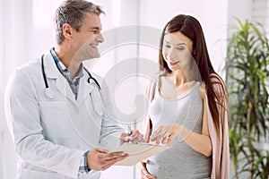 Delighted pregnant woman asking about diagnosis