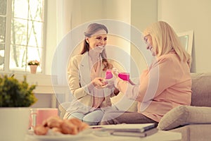 Delighted senior woman taking a gift box